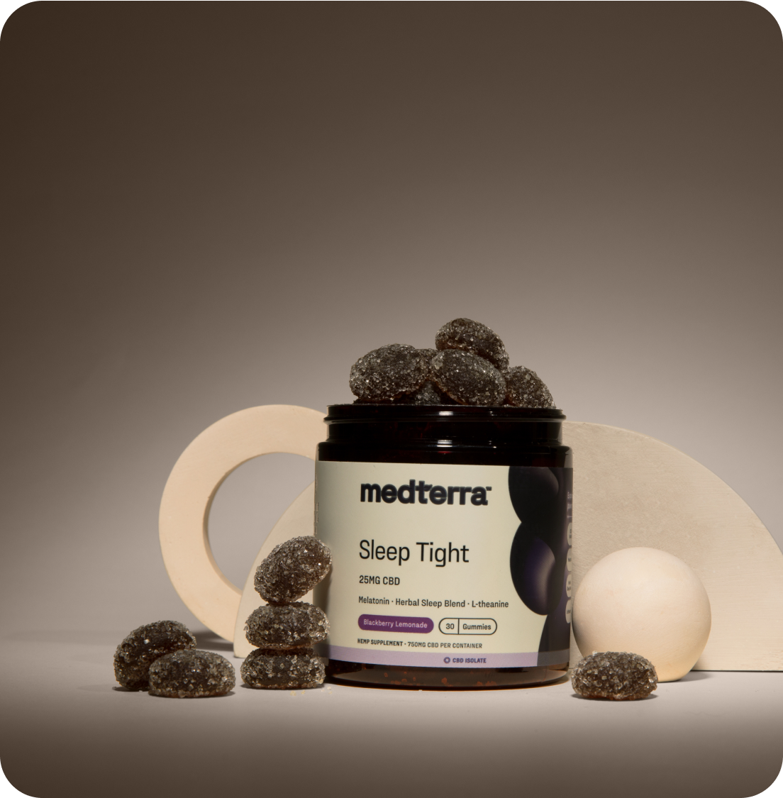Medterra Sleep Tight CBD gummies jar, open with sugar-coated blackberry-lemonade flavored gummies stacked and scattered.