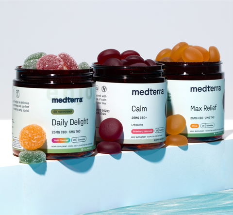 Three jars of Medterra CBD gummies: Daily Delight (mixed fruit), Calm (dark red), Max Relief (orange) with gummies scattered around.