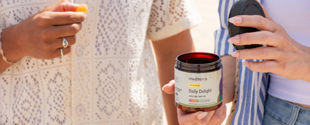 Two people holding a jar of Daily Delight CBD gummies, one person is eating a gummy.