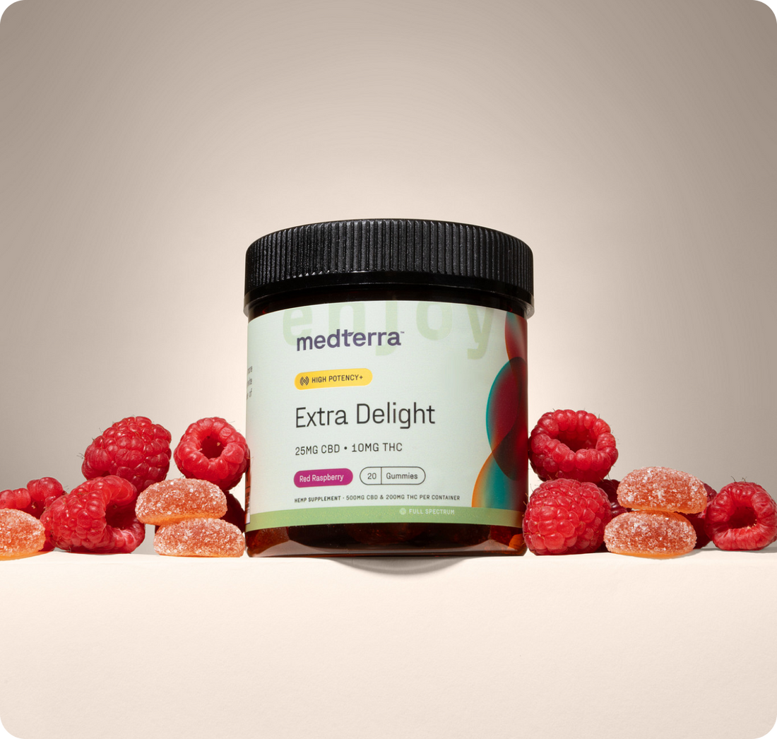 Front view of Medterra Extra Delight gummy jar labeled 25 mg CBD and 10 mg THC with raspberries on beige background