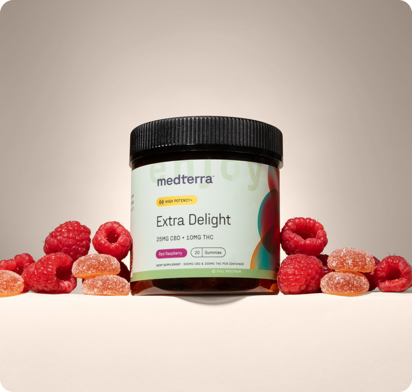 Front view of Medterra Extra Delight gummy jar labeled 25 mg CBD and 10 mg THC with raspberries on beige background