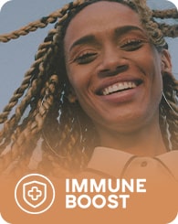 A person with braided hair smiles widely against a clear sky background. The image has an orange gradient overlay at the bottom with a shield icon and the text "IMMUNE BOOST" in white.