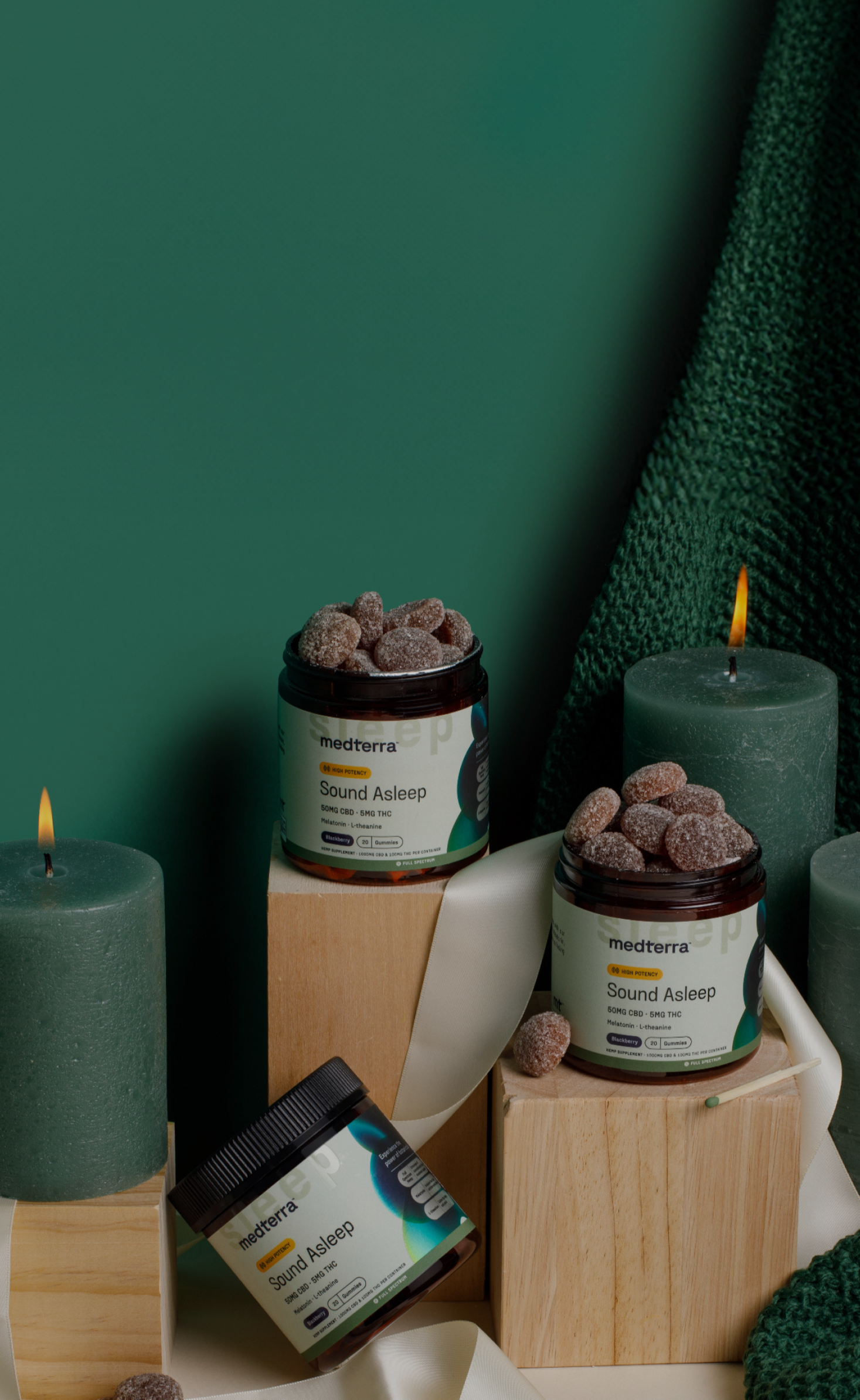 Candles and containers with visible labels against a green background