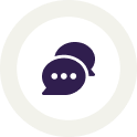 Icon featuring two overlapping speech bubbles in dark purple, positioned centrally on a white circular background with a light grey outer ring. The front speech bubble has three white dots, indicating a text conversation or messaging, symbolically grown in the USA for the highest quality communication.