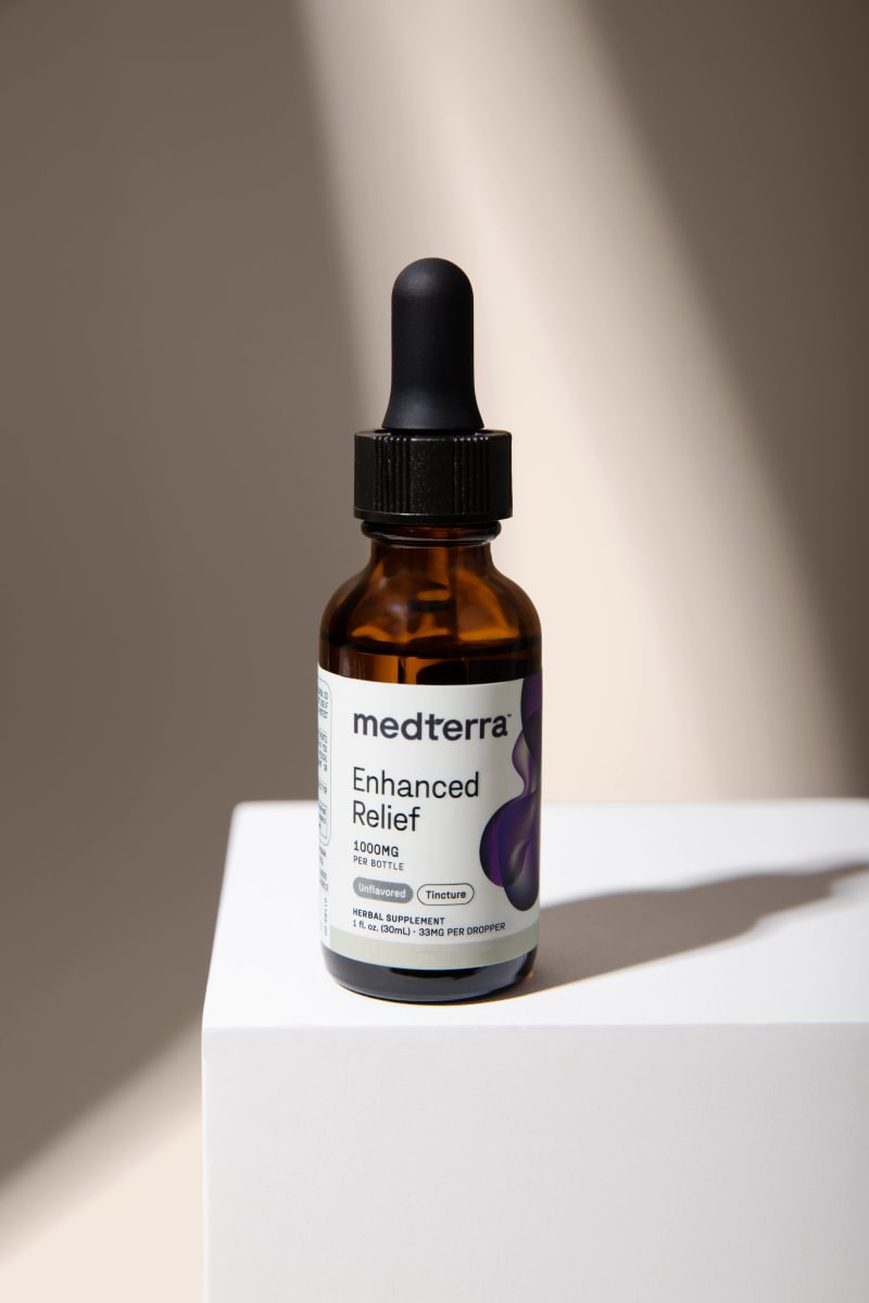 Medterra Enhanced Relief tincture on a white pedestal
