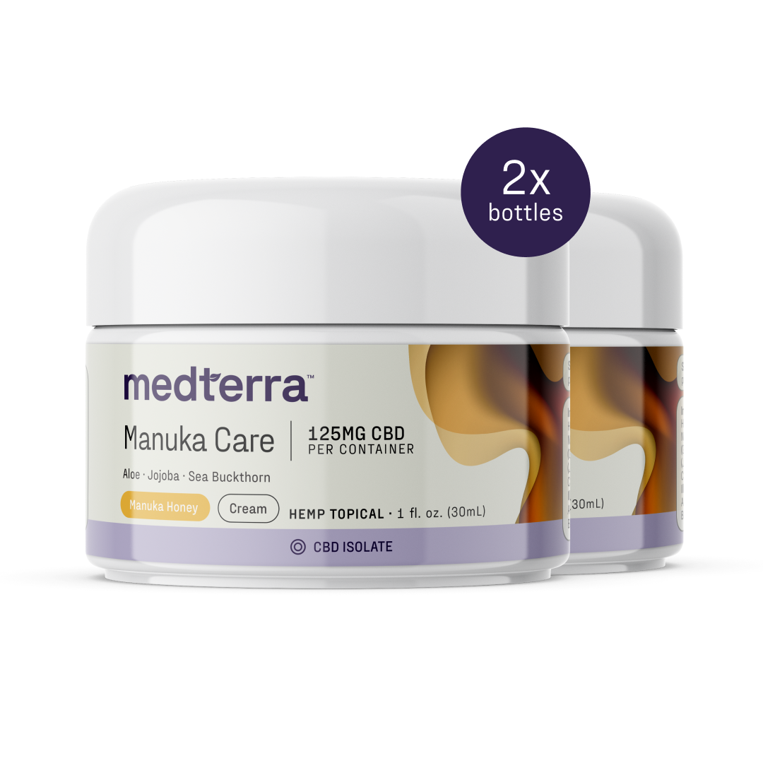 Two containers of Medterra’s Manuka Care Cream are shown, each labeled "1.25MG CBD per container," "Aloe • Jojoba • Sea Buckthorn," and "Manuka Honey." A label at the top right indicates "2x bottles," showcasing this effective skincare duo.